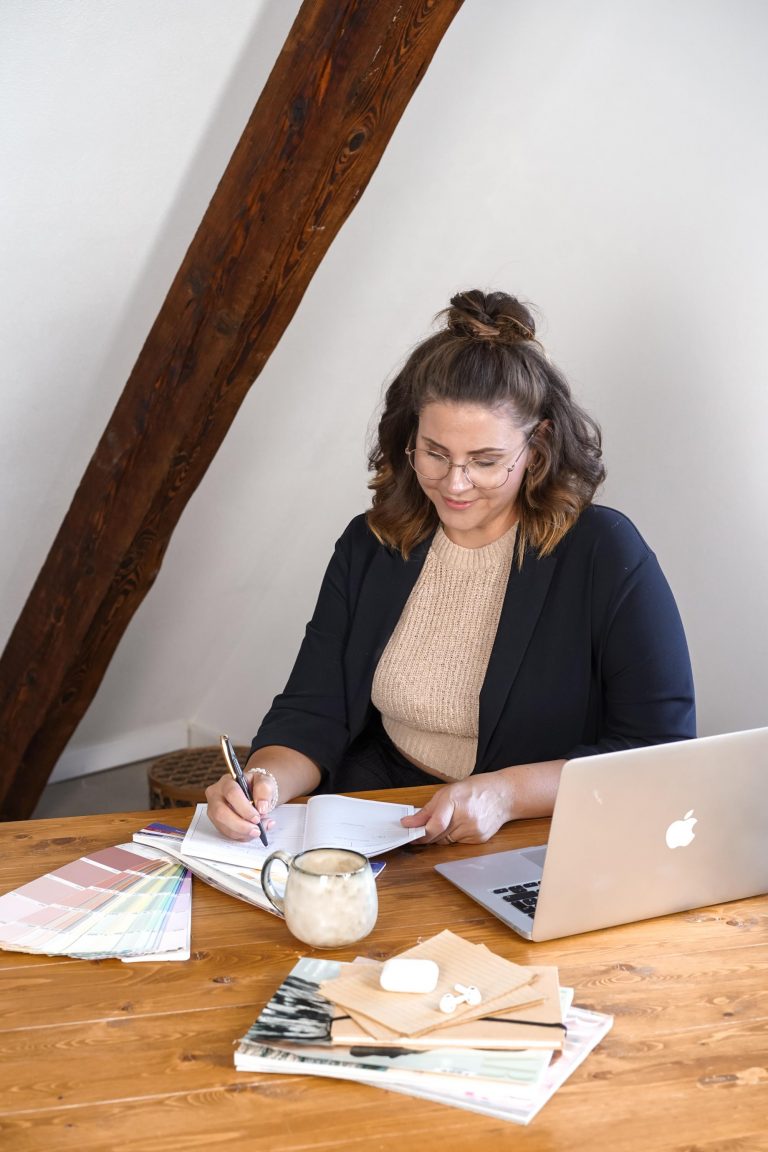 Sabrina von getSocial am Schreibtisch, schreibt Notizen zum Thema Online-Marketing für Hochzeitsdienstleister. Vor ihr der Laptop.